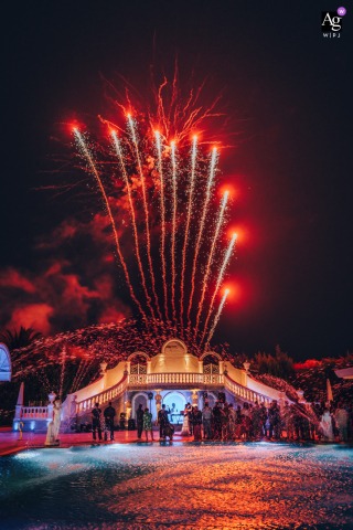 Andria's Nymphaeum comes alive with a dramatic wedding display, as fireworks burst overhead and grand water fountains frame the joyous architecture in a stunning nighttime celebration.
