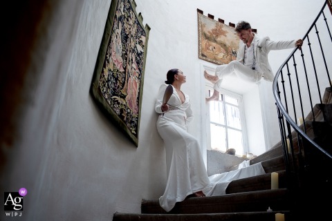 In Largentiere, France, the groom shows off his parkour skills on a staircase, climbing the wall and handrail beside the bride for an unexpected wedding portrait.