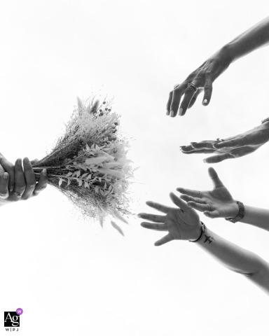 La Mouniaude, Châtel-Guyon, France: A creative composition focuses on the textural difference between the floral bouquet and the attentive hands of the wedding witnesses positioned nearby during the elegant reception at La Mouniaude.