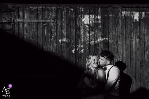 A couple smiles broadly during their sunset wedding day photoshoot in Strijen, the Netherlands, as dramatic, elongated shadows and sunlight cut diagonally across the frame.
