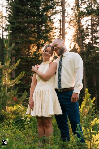 The couple stands together during the peak of golden hour at The Woodlands at Cottonwood Canyon, surrounded by the glowing mountain landscape of Bozeman, Montana.