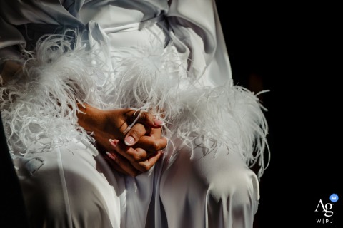 A close-up photograph artfully captures a bride's clasped hands, showcasing the delicate details of her wedding-day manicure at Hartsfield Manor, Surrey UK.