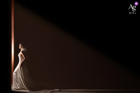 Taian, Shandong, hotel — The bride stands in profile by a large window for a minimalist solo shot indoors, bathed in soft natural light for an elegant and serene wedding portrait.