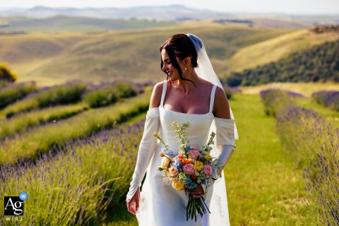 Country Relais Le Capanne, Volterra, Tuscany — The bride is captured in a solo portrait, her profile bathed in soft, warm sunlight with rolling green hills stretching behind her for a serene and elegant wedding image.