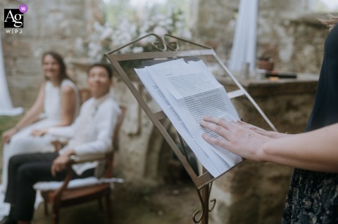 Château du Vivier, France, an artistic detail captured on the wedding day shows a guest's hand delicately holding a printed speech.