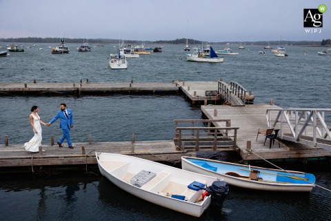 The Couple Poses For A Classic Portrait Outside The Rustic Islesford Dock Restaurant In Coastal Maine The bride and groom pose for a classic wedding portrait outside the rustic Islesford Dock Restaurant, overlooking the scenic waterfront of Islesford, Maine.