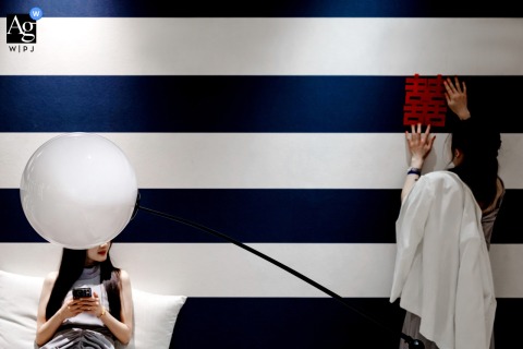 Zhanjiang, Guangdong bridesmaids focus on an artistic detail of room decor, thoughtfully arranging elements to create a cozy, festive space before the wedding day celebrations begin.