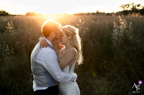 Château de Montplaisant, Montagnat (Ain - 01) — The couple poses in a field at sunset, with glowing light from behind creating an intimate and heartfelt wedding portrait filled with warmth and romance.