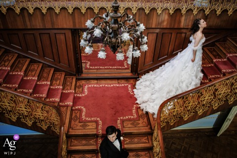 Symmetrical Artistic Wedding Portrait On Stairs At Sait Halim Paşa Yalısı Istanbul Mansion Sait Halim Paşa Yalısı, Istanbul — In a symmetrical wedding day portrait, the bride ascends the stairs while the groom walks down and away, positioned lower and center in the frame, creating a dynamic and artistic image at the historic waterfront mansion.