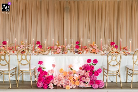 A detailed artistic photograph from the International Spy Museum, Washington DC, beautifully captures the head table adorned with a vibrant and colorful floral centerpiece, showcasing the elegant wedding day details.