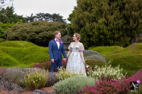 Mendocino Coast Botanical Gardens, Mendocino, CA — The bride and groom stand side by side among the blooming heathers, captured in a symmetrically framed portrait that highlights the natural beauty of the gardens.
