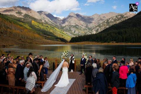 Piney River Ranch provides a stunning mountain backdrop as the bride, an artistic focal point, begins her walk down the aisle during her memorable wedding ceremony.