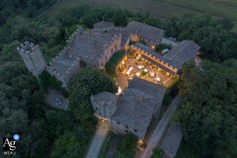 Florence, Tuscany, hosts a stunning wedding reception at a castle viewed from above, showcasing the overall grounds in an artistic drone shot that serves as a captivating scene setter for the day's celebrations.