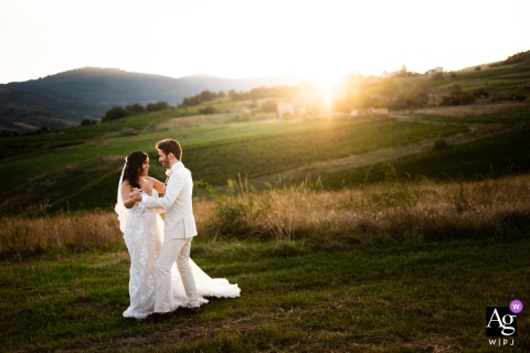 Domaine des Sources, Denicé, France — The married couple reenacts their first dance at sunset before dinner and the party, with rolling grass hills providing a romantic and scenic backdrop at the reception venue.