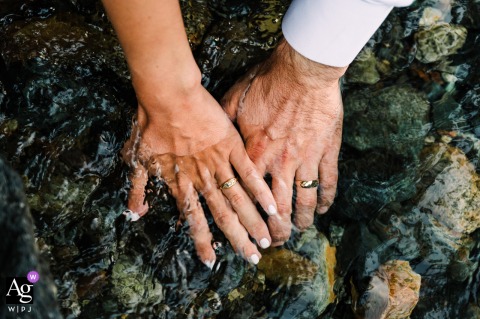 An intimate artistic detail photo taken at Morning Star Natural Resources Conservation Area captures a close-up of the couple's new wedding rings sparkling over the tranquil water of the river.