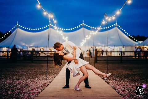 At Worcester Lodge Badminton Estate Couple Shares Romantic Kiss Under Festoon Lighting Worcester Lodge, Badminton Estate — The couple shares a romantic kiss under festoon lighting at night, with the groom dipping the bride and a warmly lit tent glowing in the background, creating an enchanting wedding portrait.
