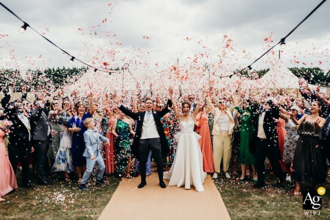 At Worcester Lodge Badminton Estate Wedding Party Group Portrait as Confetti is Thrown Worcester Lodge, Badminton Estate — The entire wedding party gathers for a group portrait as confetti is thrown high, capturing a joyful and well-executed image with everyone together in front of the historic estate.