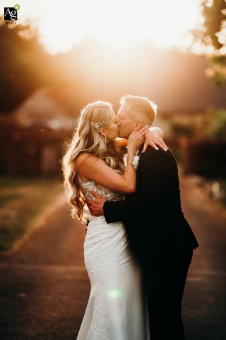 Radiant golden hour light streams around the bride and groom as they share a romantic kiss at Wick Farm in Bath, highlighting the beautiful Somerset landscape.