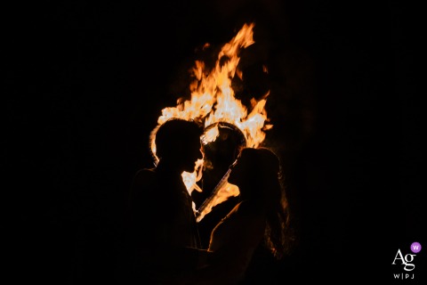 Alte Schlossfabrik, Solingen — At night, the couple's silhouetted profiles face each other in a dramatic wedding portrait, backlit by flames for a striking and artistic fire-lit effect at the venue.