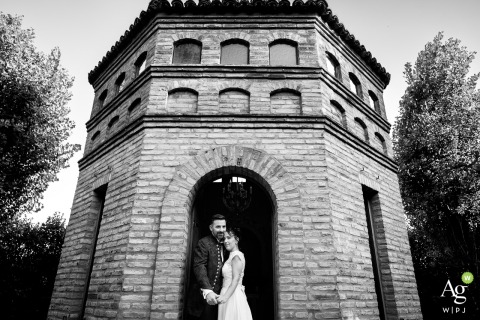 The newlyweds stand together at the ornate door of the votive chapel dedicated to Mother Mary at La Casina Residenza di Campagna in Pievedizio, Brescia.
