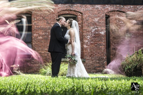 The bride and groom share a tender embrace at the historic Warner Theatre in Erie, Pennsylvania, as the bustling world whirs around them in a blur.