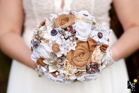 A detailed photograph created in the Domaine des Pindouls park in Haute-Garonne shows the bride holding her wedding bouquet, which was crafted by a seamstress from various textured fabrics and sewn-on objects.