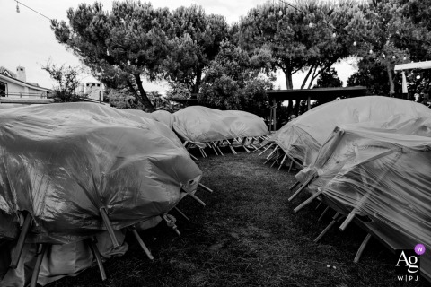 Grandma's Wonderland, Turkey, after a rain shower on the wedding day, an artistic black and white detail captures the formal rows of chairs completely covered by protective tarps.