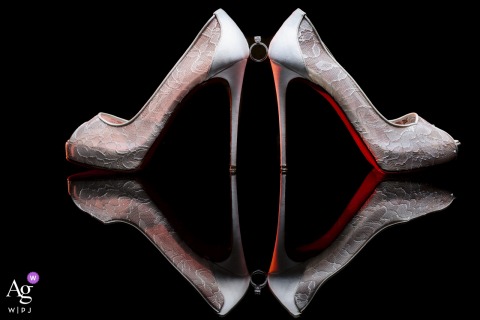 An artistic reflection shot at the Zephyr Palace, Villa Caletas Hotel in Jaco, Costa Rica, highlights the bride's white wedding shoes with their distinctive red sole, creatively accented alongside her sparkling engagement ring.