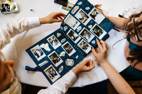 Rise Hall, Yorkshire, England, presents a thoughtful detail photograph of young guests at a wedding reception carefully decorating a scrapbook.