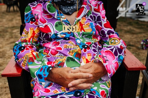 Wolds Way Farm, Yorkshire, England, is the setting where a unique detail is captured: a wedding guest stands out in a vibrant, artistic take on a disco fancy dress costume.