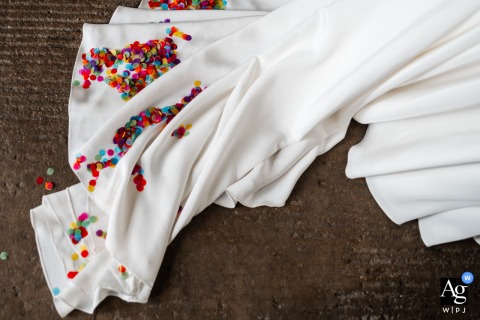 Colourful confetti rests lightly on the bride's beautiful white dress at Woolas Barn, a detail captured on the wedding day in York, England.