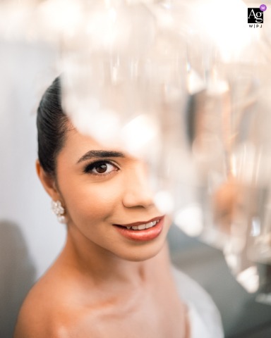 Espaço Natureza — In a high-angle portrait, the bride looks up at the camera through hanging crystals, creating an artistic and ethereal effect for her wedding image at this elegant venue.