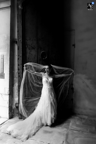 Black And White Portrait Of The Bride Playing With Her Veil In An Ancient Palace Doorway In Forlì, Italy Black and white portrait of a bride playing with her veil in an ancient palace doorway in Forlì, Italy.