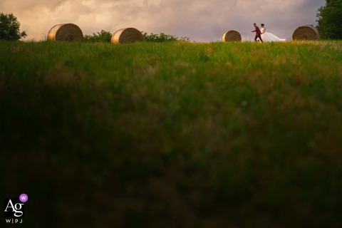   At a Gironde reception venue, the couple is seen running together through vibrant fields, the joyful motion and wide scenery highlighting their celebration.