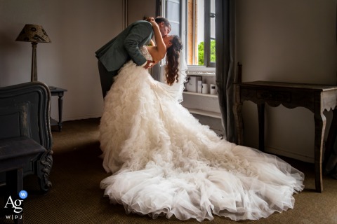 At La Bastide 1631 In Le Castellet, Var, France, The Couple Kisses By A Sunlit Window, Framing Their Intimacy Indoors At la Bastide 1631 in Le Castellet, Var, France, the couple is captured sharing a kiss by a sunlit window in their room, framing their intimacy indoors.