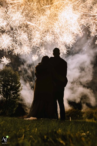 Bride and Groom Stand at Night as Fireworks Light Sky at Landgut Stuttem Wipperfurth Germany At Landgut Stüttem in Wipperfürth, Germany, the bride and groom stand together at night as fireworks go off, marking their celebration with a display above the venue grounds.