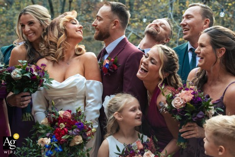   Laughter fills the air as the wedding party gathers with the bride at Willow Falls Resort, the group sharing joyful camaraderie in this lively reception scene.