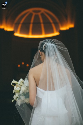 In Tuscany, The Bride Is Highlighted Against The Orange Glow Of The Church Roof For An Elegant Detail In Tuscany, the bride is photographed from behind, she is highlighted against the orange glow of the church roof for an elegant wedding detail.