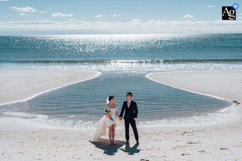   Walking along a bright, empty shore on Long Island, the couple is surrounded by shimmering light, the tranquil beach scene highlighting their connection.