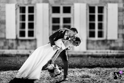 The Grounds Of Château La Hitte In France Frame The Dipping and Kissing Wedding Portrait With Elegant Architecture And Landscaped Gardens The grounds of Château La Hitte in France frame a portrait of the kissing couple, with elegant architecture and landscaped gardens enhancing their wedding day image.
