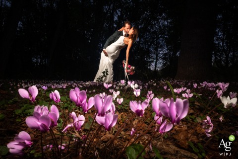 Bride and Groom Photographed With Wild Cyclamen Pink and Purple Flowers at Domaine de Belisle in Charente France At Domaine de Belisle in Charente, the bride and groom are photographed in front of wild cyclamen flowers, with the natural surroundings bringing color and life to the portrait.