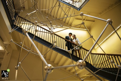 Couple Poses on MIT Stairs in Cambridge Massachusetts With Scientific Model as Distinctive Backdrop A couple poses on the stairs at MIT in Cambridge, Massachusetts, a scientific model providing a distinctive backdrop that references their shared connection to the location.