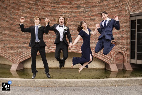 Outside MIT Chapel In Cambridge, Massachusetts, The Groom And Friends Leap High For A Joyful And Energetic Group Wedding Portrait Outside MIT Chapel in Cambridge, Massachusetts, the groom and his friends leap into the air for a fun and energetic group portrait, capturing the joy of the day.