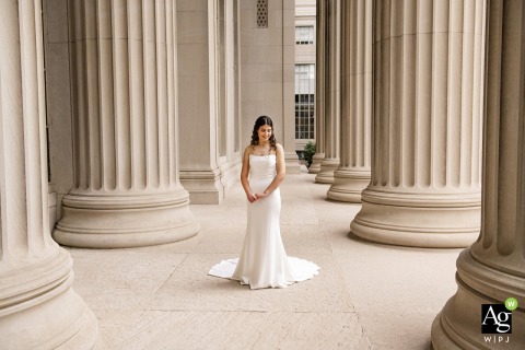 Bride Stands Among Tall Columns at MIT Campus in Cambridge Massachusetts Emphasizing Architecture On the campus of MIT in Cambridge, Massachusetts, the bride stands alone among towering old world columns, her pose emphasizing the scale and architectural lines of the setting.