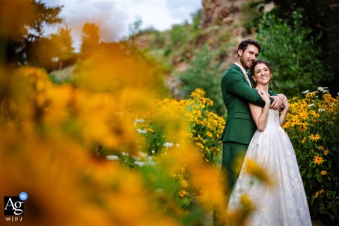   At River Bend in Lyons, Colorado, the newlyweds snuggle amongst blooming wildflowers, the garden setting enveloping them in vibrant natural beauty.