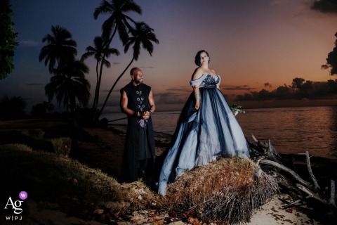   Pigeon Point Beach in Tobago sets the scene for a post-wedding sunset portrait of an unconventional bride and groom, the colorful sky enhancing their unique style.