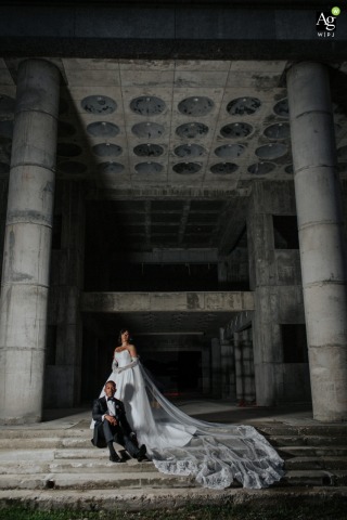 Couple Poses on Reception Steps Overlooking Future Venue Site in Port of Spain Trinidad and Tobago A couple portrait on the steps of a reception location in Port of Spain, Trinidad & Tobago, with a view of the proposed site for a future wedding venue on the same compound.