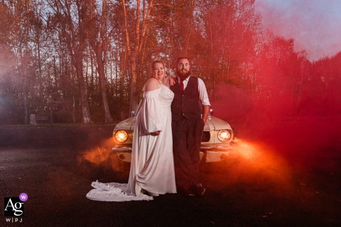   At Rockn TJ Ranch in Montana, the couple stands in front of their Mustang, the dramatic scene enhanced by a haze of smoke surrounding them.