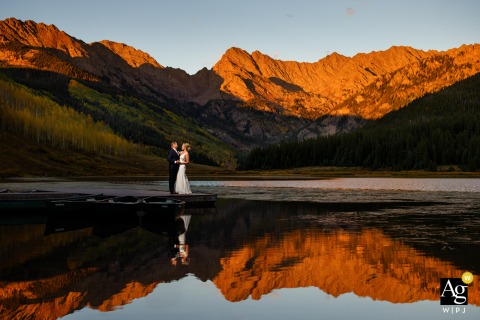 Bride And Groom Pose Together On A Dock During Alpenglow At Piney Lake, Creating A Scenic Piney River Ranch Portrait Bride and groom pose together on a dock at Piney Lake during alpenglow at Piney River Ranch.