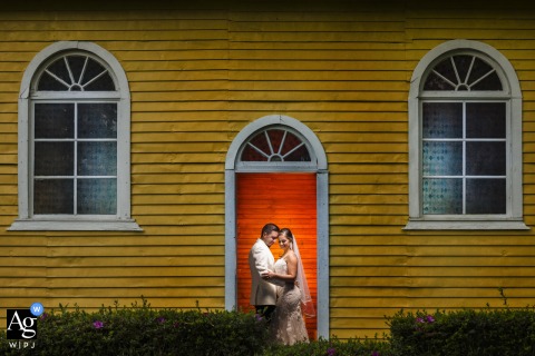 A Creative Portrait Of The Newlyweds Set Against The Small Wood Chapel At Hacienda Sitio De Mata In Costa Rica The small wood chapel at Hacienda Sitio de Mata in Pavones Turrialba, Costa Rica, is the backdrop for a creative wedding portrait of the newlyweds.